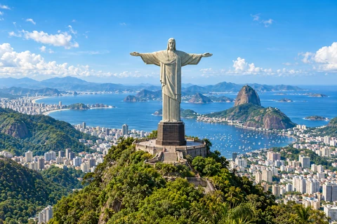 Christ the Redeemer above the green hills and blue bay of Rio de Janeiro.